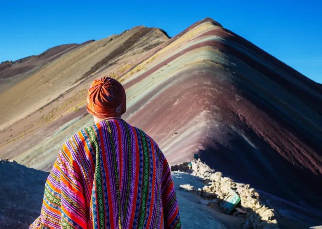 Viajero con poncho frente a la Montaña de 7 Colores